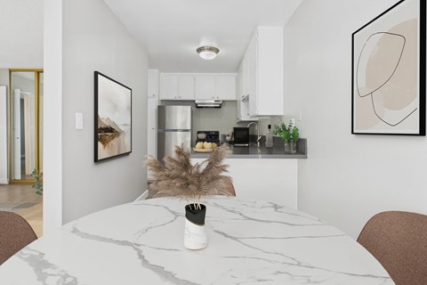 A modern kitchen with a marble table and a framed picture on the wall.