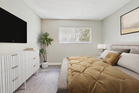 A bedroom with a large bed and a TV on the wall.