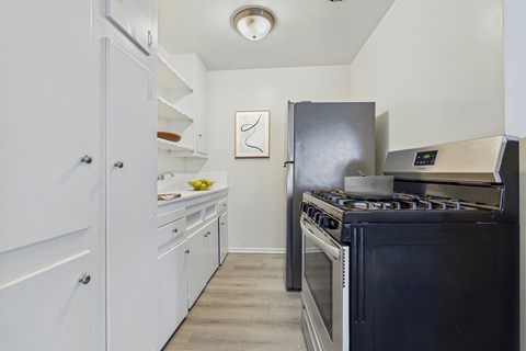 A kitchen with a black stove top oven and white cabinets.