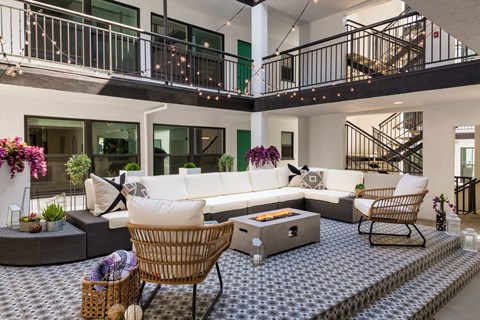 A modern living room with a white sofa and a wicker chair.