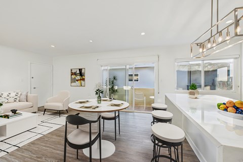 A modern dining room with a white table and chairs.