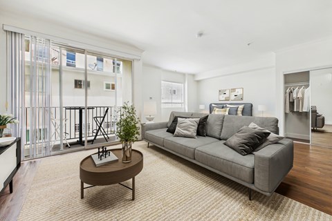 A living room with a grey couch and a brown coffee table.
