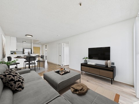 A living room with a grey couch and a wooden cabinet.