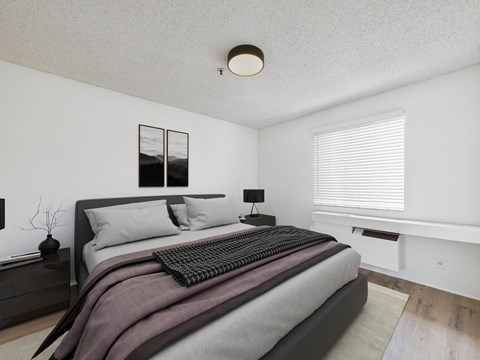A bedroom with a large bed and a window with blinds.