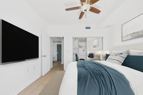 A bedroom with a large bed and a ceiling fan.