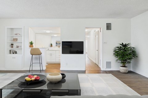 A modern living room with a black coffee table and a flat screen TV.