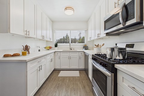 A kitchen with white cabinets and a black stove top.