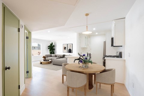 a living room and dining room with a table and chairs