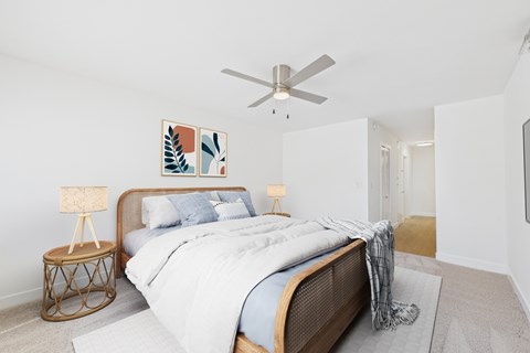 A bedroom with a large bed and a ceiling fan.