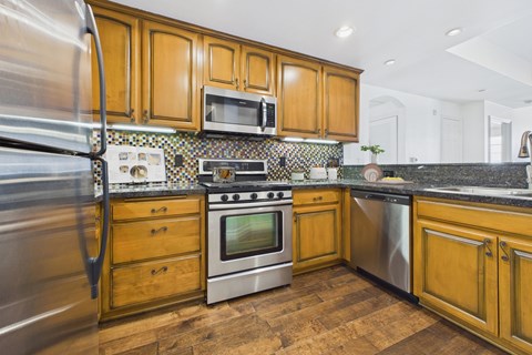 A kitchen with wooden cabinets and stainless steel appliances.