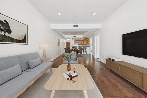 A modern living room with a grey sofa and a wooden coffee table.