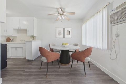 A kitchen with a dining table and chairs.