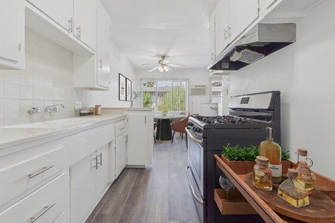 A modern kitchen with white cabinets and a wooden island.
