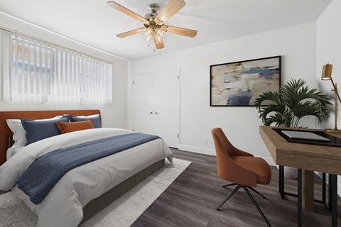 A bedroom with a bed, desk, and chair.