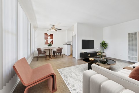 A living room with a white couch and a red chair.