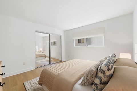 A bedroom with a bed and a mirror on the wall.