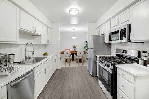 A kitchen with white cabinets and appliances.