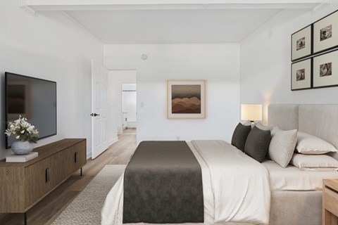 A bedroom with a large bed and a flat screen TV.
