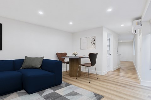 A blue couch sits in a living room with a brown chair and a small table.