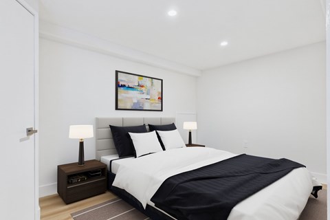 A bedroom with a large bed and a painting on the wall.