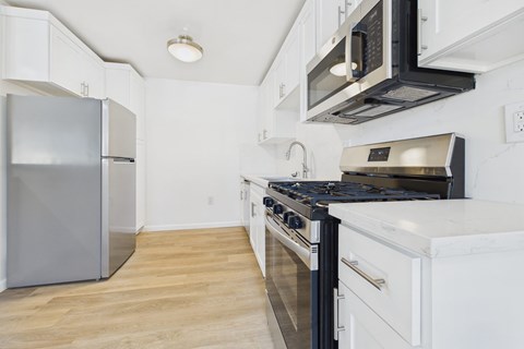A kitchen with a stove top oven and a refrigerator.