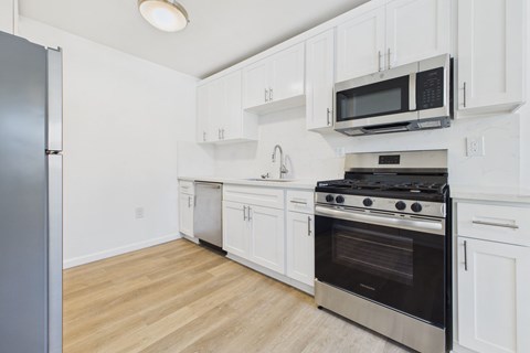 A kitchen with white cabinets and a black stove top oven.