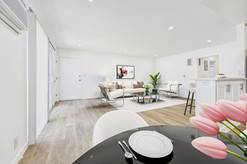 A modern living room with a dining table set for two.
