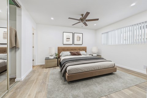 A bedroom with a large bed and a ceiling fan.