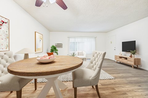 A living room with a round wooden table and chairs.