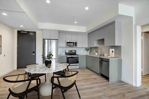 A modern kitchen with a dining table and chairs.