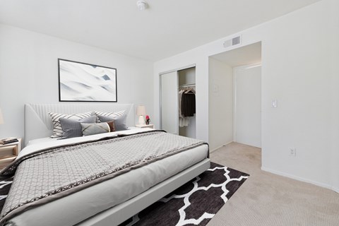 A bedroom with a large bed and a painting on the wall.