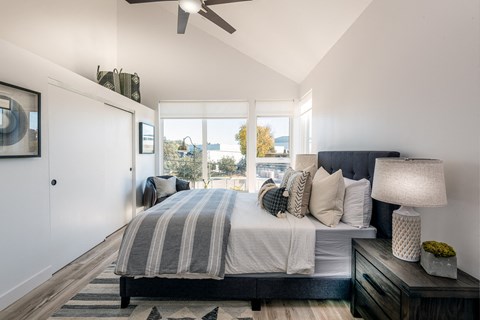 A bedroom with a large bed and a ceiling fan.