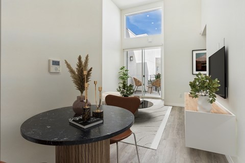 A modern living room with a round table and a flat screen TV.