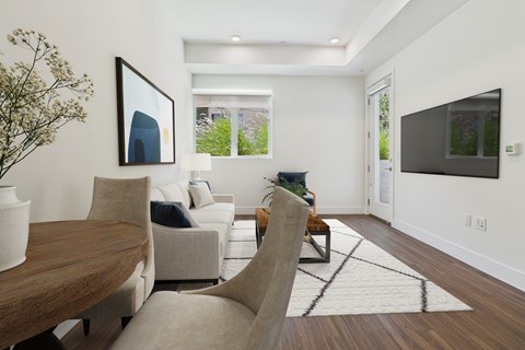 A modern living room with a wooden table and a large painting on the wall.