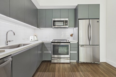 A modern kitchen with a stainless steel refrigerator and oven.