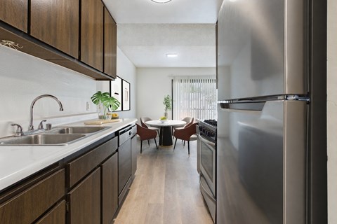 A modern kitchen with a stainless steel refrigerator and wooden cabinets.