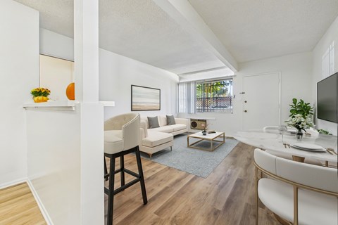 A living room with a white couch and a wooden floor.
