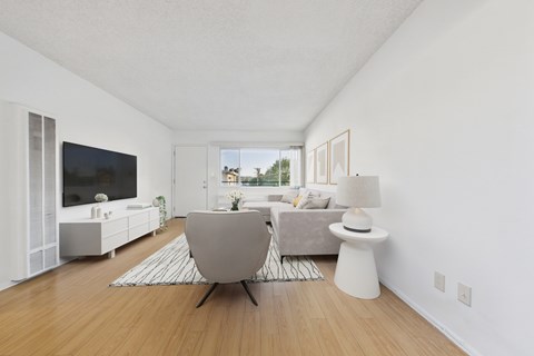 A modern living room with a grey chair and a white side table.