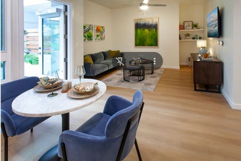 A living room with a white table and blue chairs.