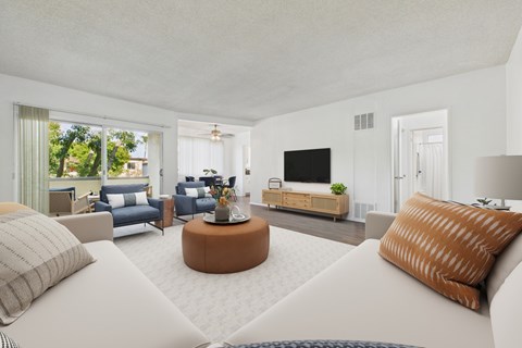 A modern living room with a white sofa and a brown pillow.