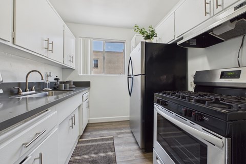 A modern kitchen with a black refrigerator and stove.