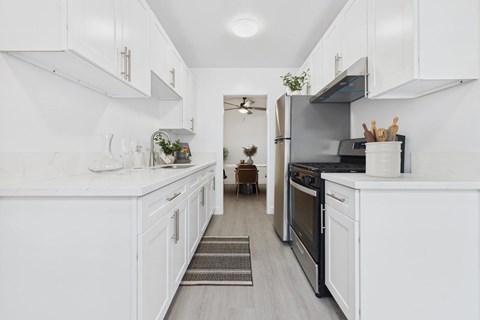 A kitchen with white cabinets and appliances.