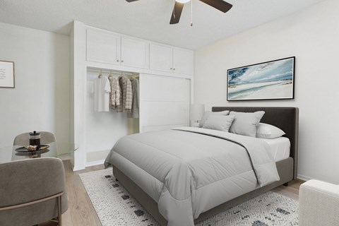 A bedroom with a large bed and a ceiling fan.