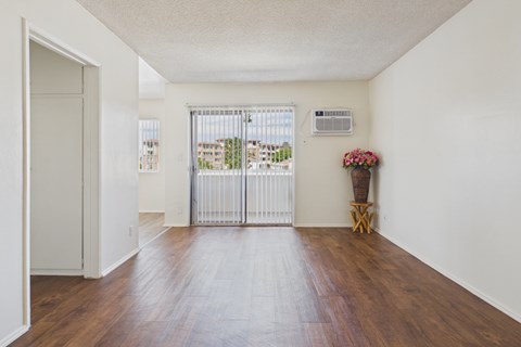 A white room with a wooden floor and a white door.