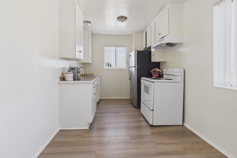A kitchen with white cabinets and appliances.