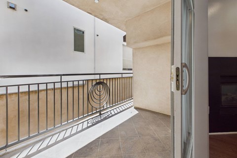 A balcony with a metal railing and a white door.