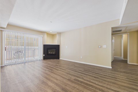 A spacious living room with a fireplace and sliding glass doors.