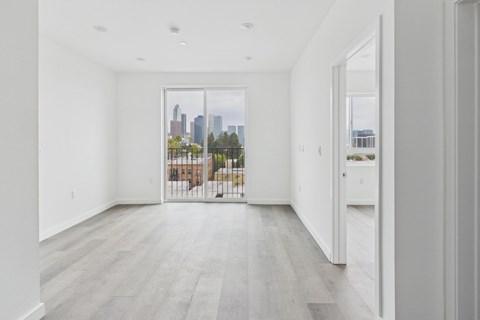A spacious room with a view of the city skyline through the window.