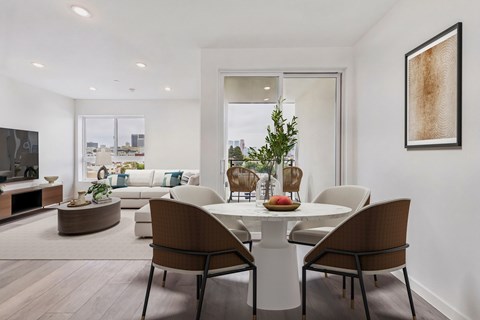 A modern dining room with a white table and chairs.