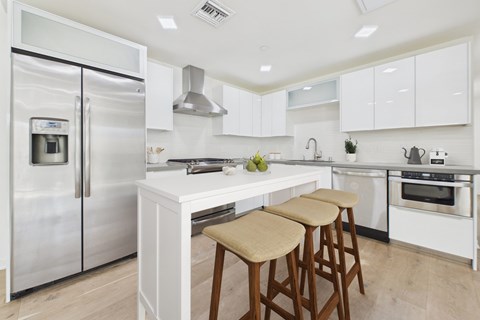 A modern kitchen with white cabinets and a stainless steel refrigerator.